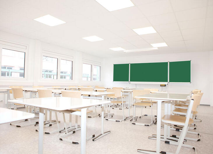 Ljust klassrum med bord och stolar Ljust klassrum med bord och stolar