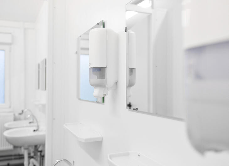 Insidan av en sanitetsmodul med speglar och handfat Insidan av en sanitetsmodul med speglar och handfat