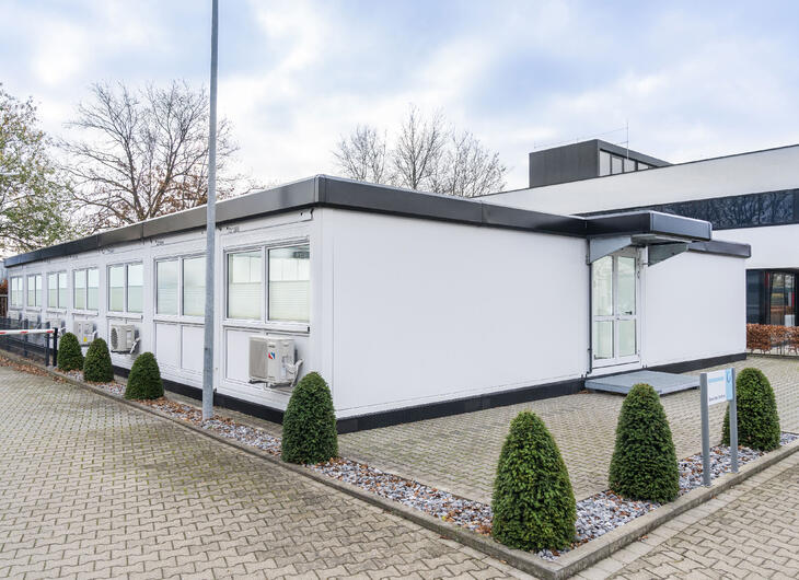 Vit modulanläggning med svarta kanter som matchar huvudbyggnaden Vit modulanläggning med svarta kanter som matchar huvudbyggnaden