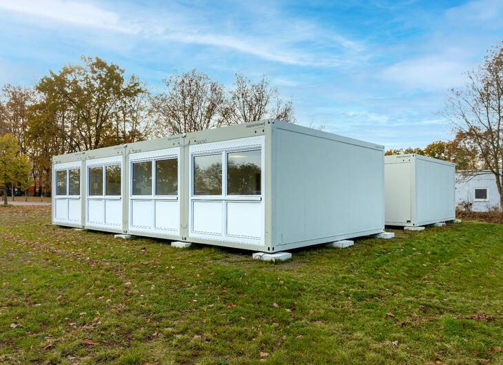 Två rader med uppställda skolmoduler Två rader med uppställda skolmoduler