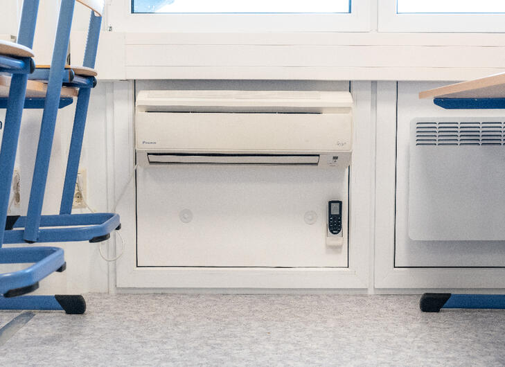Väggmonterad AC och element under fönsterna i ett klassrum Väggmonterad AC och element under fönsterna i ett klassrum