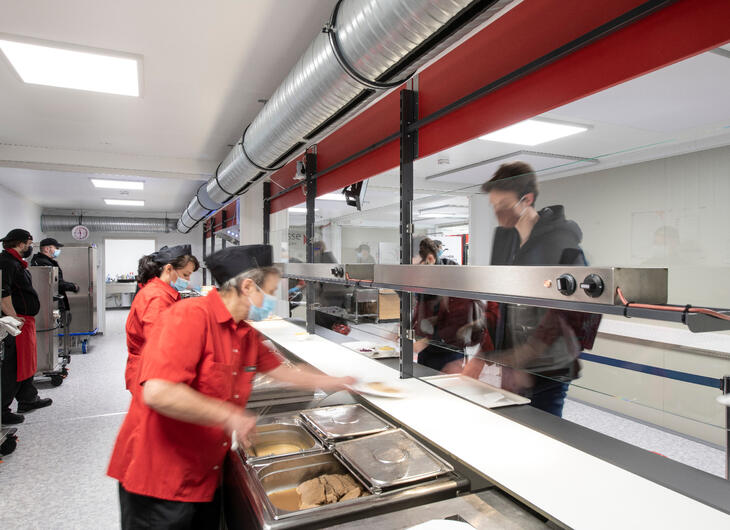 Serveringspersonal som serverar lunch över disken Serveringspersonal som serverar lunch över disken