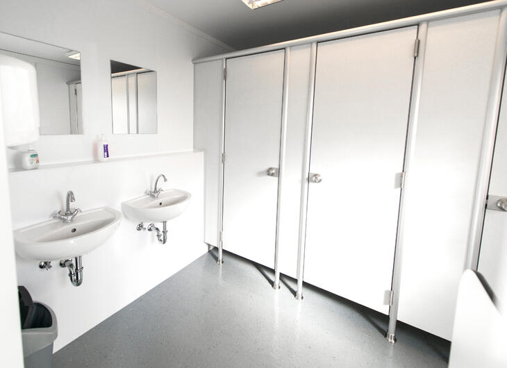 Sanitetsmodul med toalettbås, handfat och speglar Sanitetsmodul med toalettbås, handfat och speglar