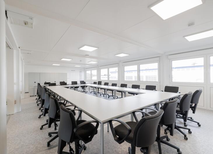 Stort mötesrum med bord och bekväma stolar
