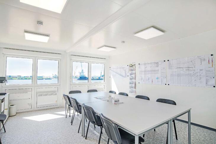 Ljust mötesrum med bord och stolar