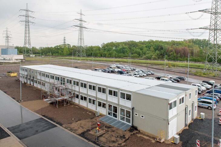 Stor modulanläggning med entrédel och parkeringsplats