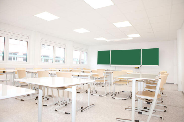 Ljust klassrum med bord och stolar Ljust klassrum med bord och stolar