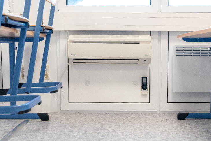 Väggmonterad AC och element under fönsterna i ett klassrum Väggmonterad AC och element under fönsterna i ett klassrum