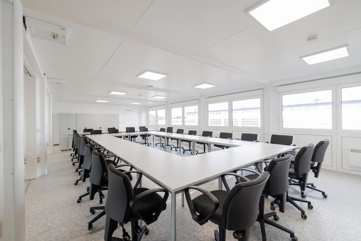 Stort mötesrum med bord och bekväma stolar