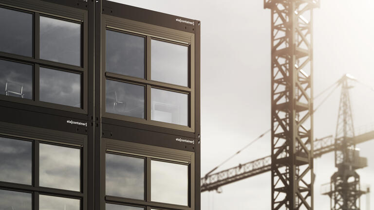 Modulanläggning i flera våningar med en kran i bakgrunden