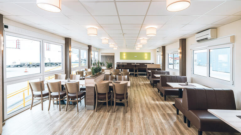 Insidan av en restaurangmodul med bord och stolar