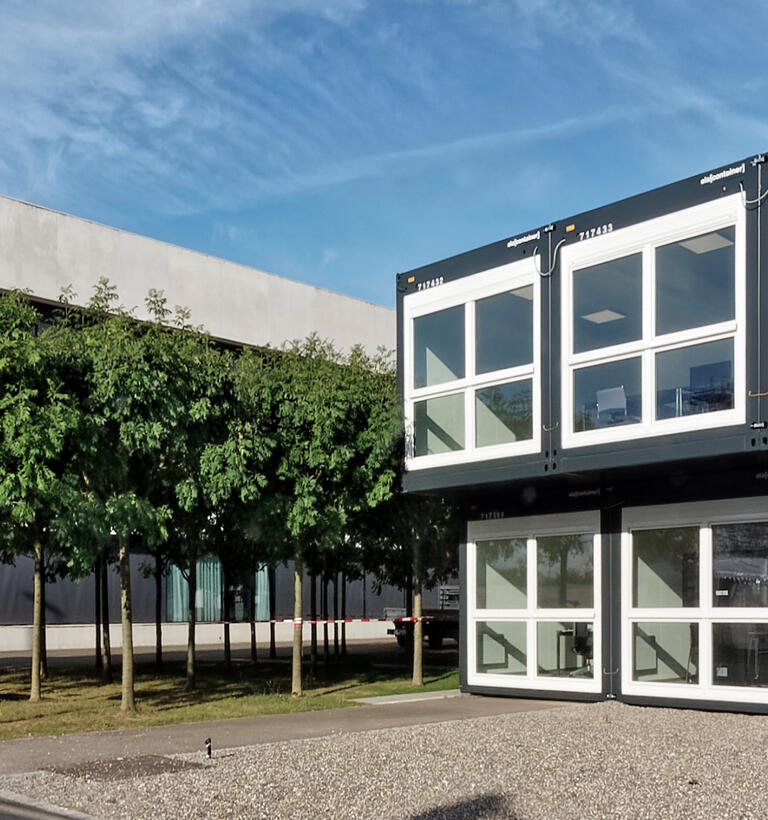 ELA container building set by a row of trees